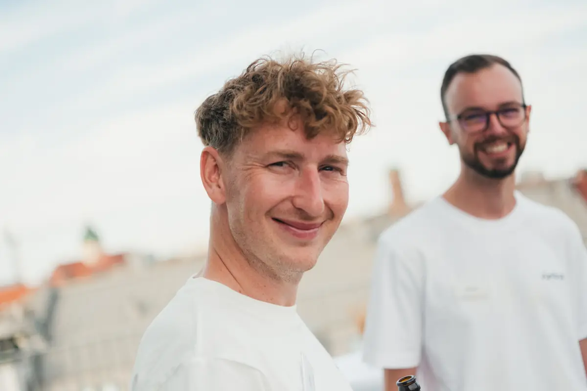 Zwei Kollegen auf der Dachterrasse über den Dächern Münchens