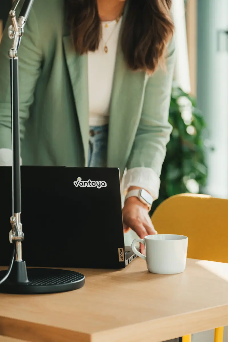 Laptop mit Vantoya-Sticker und Kaffeetasse