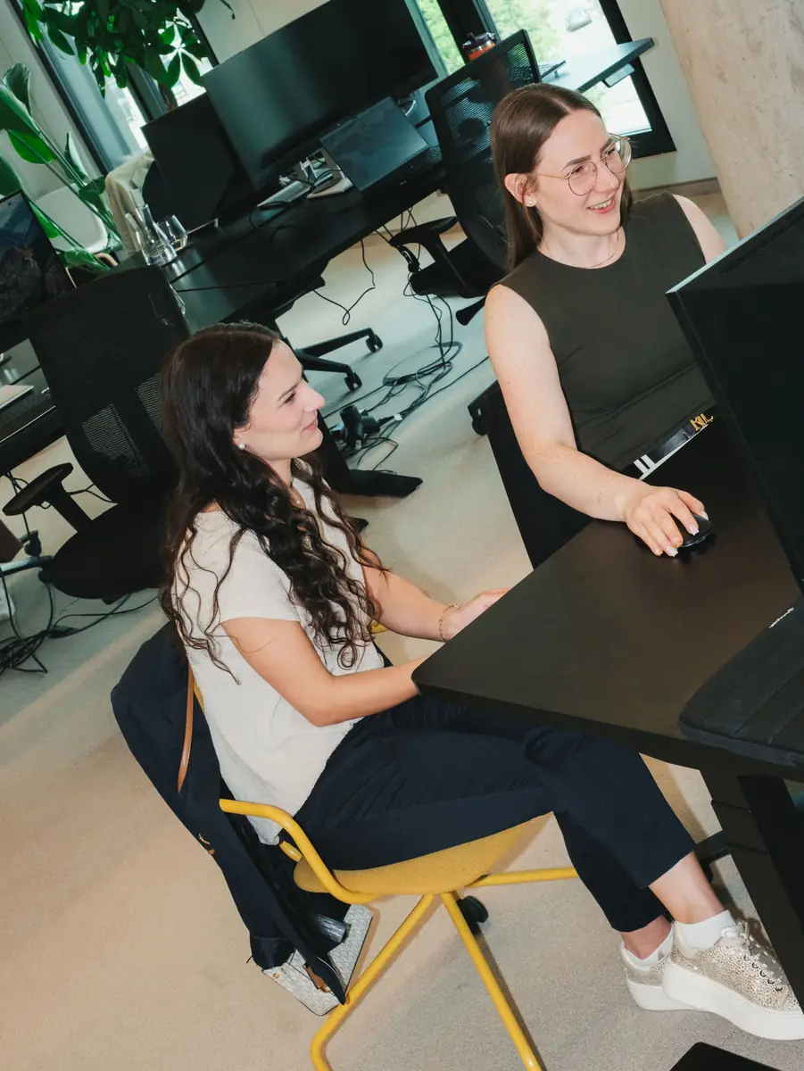 Two colleagues talking at their workspace