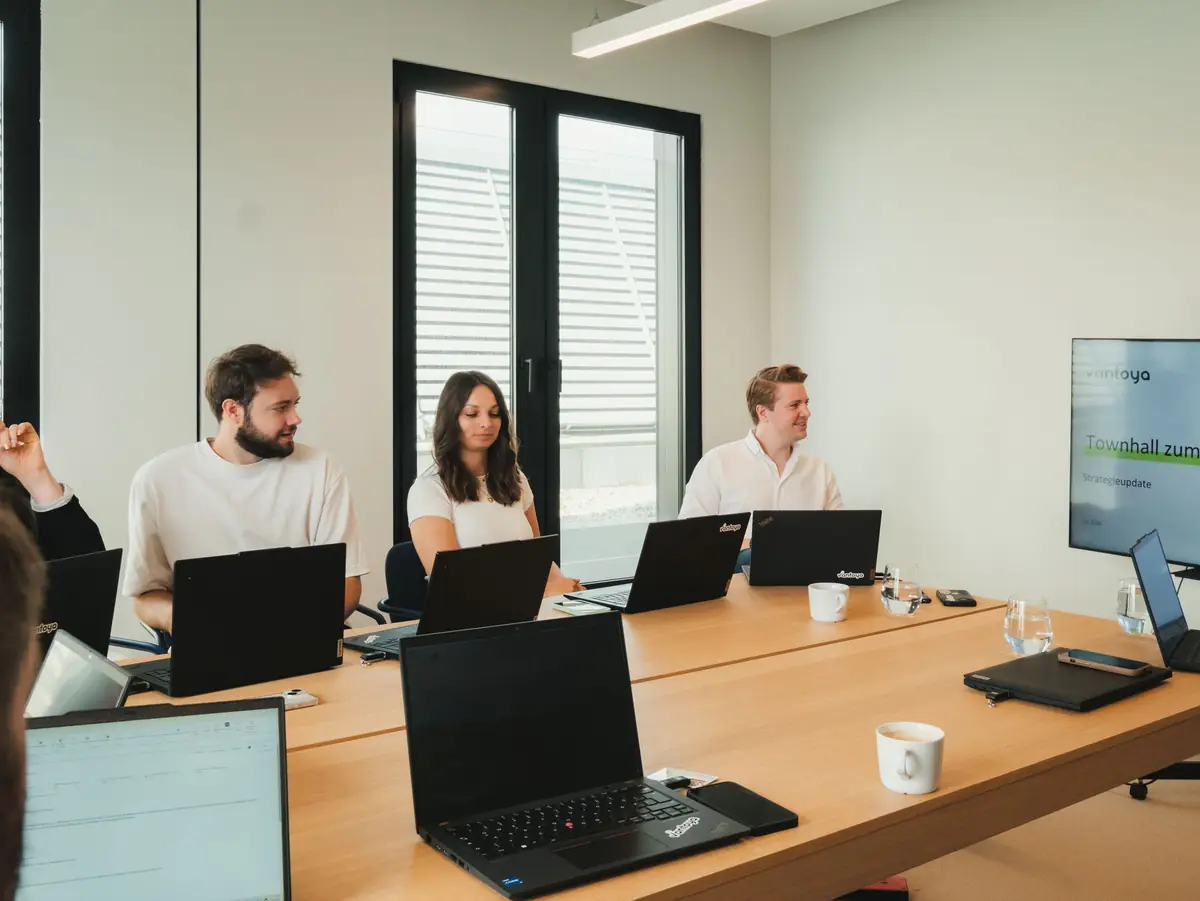 Team meeting with laptops and a screen